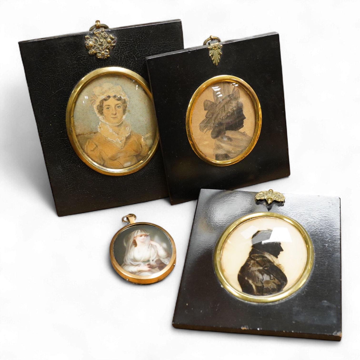 Two 19th century silhouette portraits to include one painted on glass by R. N. Barnes 1836 together with a portrait miniature of a Regency lady and an enamel example, largest 8 x 6.5cm (4)